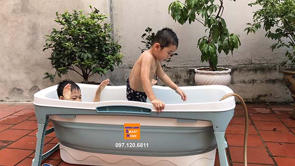 Hai bé nô đùa thích thú với bồn tắm gấp gọn